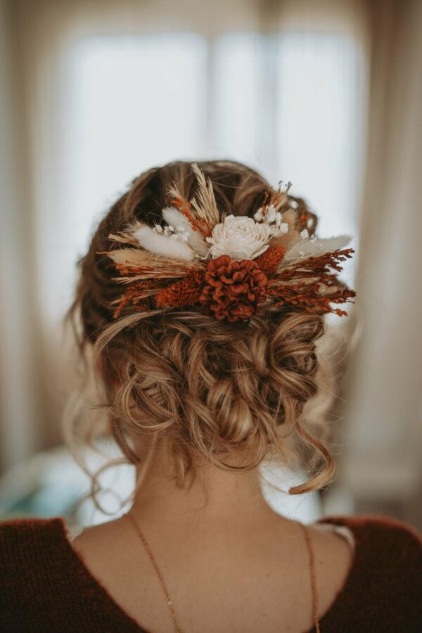 Coiffure champêtre mariage en chignon bouclé avec des fleurs séchées
